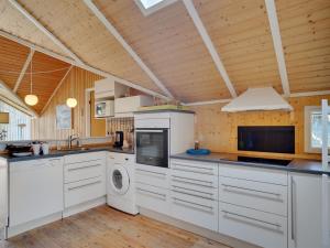 a kitchen with white cabinets and a washer and dryer at Holiday Home Norna - 300m from the sea by Interhome in Store Fuglede