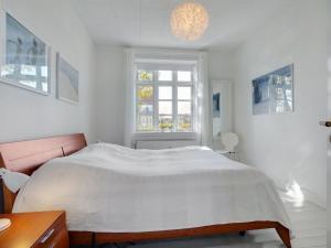 a white bedroom with a bed and a window at Apartment Starki - 800m from the sea by Interhome in Skagen