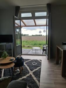 a living room with a view of a field at B&B weidse blik Ingelum in Engelum