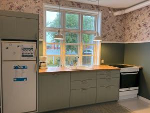 a kitchen with a white refrigerator and a sink at Apartment Tobias - 800m from the sea by Interhome in Skagen