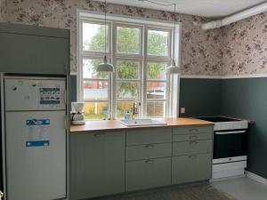 a kitchen with a white refrigerator and a window at Apartment Tobias - 800m from the sea by Interhome in Skagen