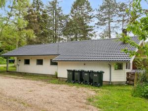a white house with three trash cans in front of it at Holiday Home Juke - 425m from the sea by Interhome in Nyrup
