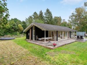 a small cabin with a deck in a yard at Holiday Home Heino - 3-5km from the sea by Interhome in Frederiksværk