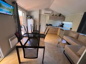 un soggiorno con sedie, un tavolo e un divano di 531 Mobi-Chalet 3 chambres 2 sd Bassin d'Arcachon a La Teste-de-Buch