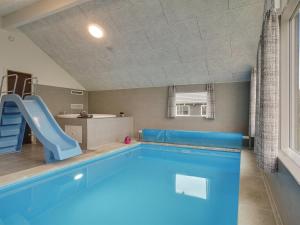 a large swimming pool with a slide and a swimming pooliterator at Holiday Home Vara - 800m from the sea by Interhome in Vejby