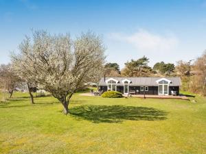a house in a field with a tree in the yard at Holiday Home Trajko - 100m from the sea by Interhome in Hou