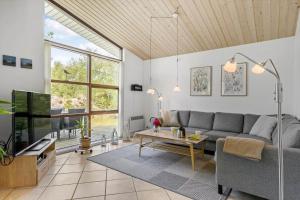 a living room with a couch and a tv at JB828-Fjerritslev-Revlingestien-71 in Torup Strand