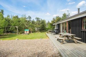 a wooden deck with a picnic table and a playground at JB828-Fjerritslev-Revlingestien-71 in Torup Strand
