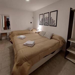 a bedroom with a large bed with towels on it at Complejo Los Horneros - Departamento in La Porteña