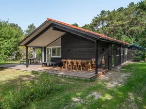 a cabin with a deck with a table and chairs at Holiday Home Efka - 175m from the sea by Interhome in Asnæs +16 photos