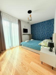 ein Schlafzimmer mit einem Bett und einer blauen Wand in der Unterkunft Boulevard Vistula Apartment Swimming Pool, Sauna, Gym & Parking in Krakau + 31 Fotos