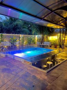einen Pool auf einer Terrasse mit Stühlen und einem Tisch in der Unterkunft Debayview Hotel in Asaba