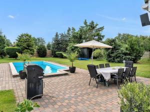 a patio with a table and chairs next to a pool at Holiday Home Fentje - 375m to the inlet by Interhome in Grevinge