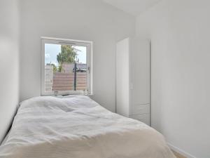 a white bedroom with a bed and a window at Holiday Home Fentje - 375m to the inlet by Interhome in Grevinge +16 photos