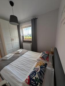 a bedroom with a bed with two pillows on it at Apartament Przy Potoku in Zubrzyca Górna