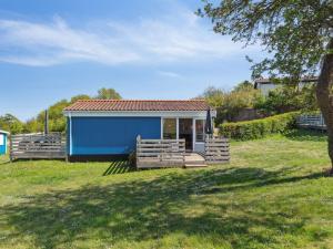 una piccola casa blu in un campo erboso di Apartment Kjera - 200m from the sea by Interhome ad Allinge