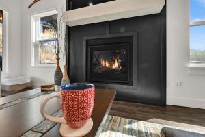 een koffiekopje op een tafel voor een open haard bij Brand NEW Entire home in Eden Utah in Eden