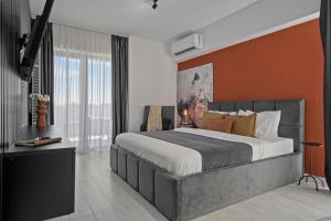 een slaapkamer met een groot bed met een oranje muur bij Terracotta Oasis in Boekarest