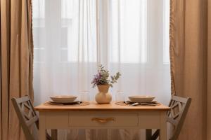a table with two plates and a vase with flowers on it at Rouen cœur historique in Rouen