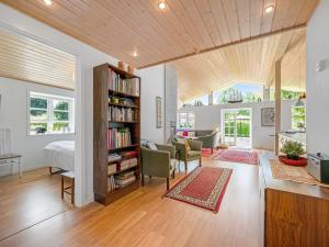 een woonkamer met een boekenplank en een bank bij Holiday Home Melle - 350m from the sea by Interhome in Dronningmølle