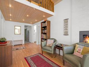 een woonkamer met stoelen, een tafel en een open haard bij Holiday Home Melle - 350m from the sea by Interhome in Dronningmølle