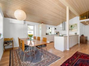 een keuken en eetkamer met een houten plafond bij Holiday Home Melle - 350m from the sea by Interhome in Dronningmølle