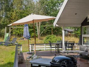 a patio with an umbrella and tables and chairs at Holiday Home Amola - 1-6km from the sea by Interhome in Højby