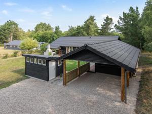 a house with a black roof and a garage at Holiday Home Kunegunda - 650m from the sea by Interhome in Yderby
