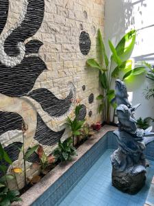 un jardín con una pared de piedra y una fuente en Danang's house, en Da Nang