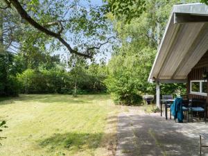 a patio with a table and a grill in a yard at Holiday Home Kerrin - 300m from the sea by Interhome in Asnæs