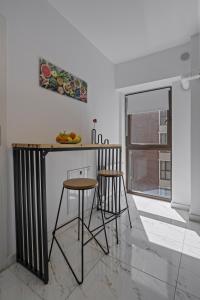 een keuken met een aanrecht en krukken in een kamer bij Terracotta Oasis in Boekarest