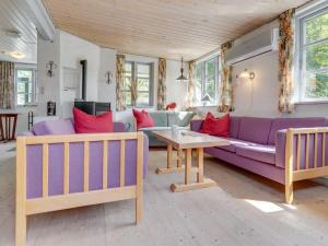 a living room with a purple couch and a table at Holiday Home Sini - 300m from the sea by Interhome in Gedser