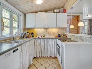 a kitchen with white cabinets and a sink at Holiday Home Sini - 300m from the sea by Interhome in Gedser
