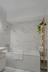 een witte badkamer met een bad en een wastafel bij Terracotta Oasis in Boekarest