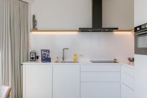 伊特博尔德Coastal Getaway - Free Parking & Balcony - Baldus的带白色橱柜和水槽的厨房