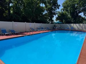 a large swimming pool with chairs and a fence at Long term 1BR w Balcony & Parking Near Philly in Jenkintown