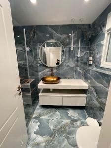 a bathroom with a sink and a mirror at Crown Suite in Qiryat Motzkin