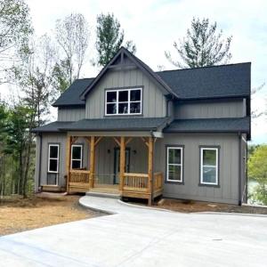 a tiny house with a porch and a gambrel roof at The Overlook at Lake James in Nebo