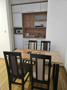 a kitchen with a wooden table and four chairs at Apartman Marija II in Vrnjačka Banja