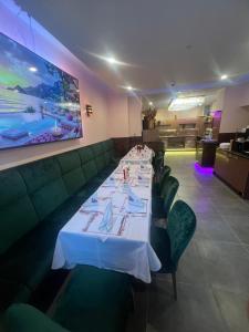 a dining room with a long table and green chairs at Hotel Golden Pearl Magdeburg im Stadtzentrum in Magdeburg