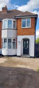 a brick house with a black and white front door at Parkdale-2 Bedroom House in Sheldon Birmingham in Birmingham