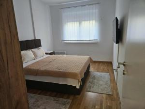 a bedroom with a bed and a window and a door at Apartman Marija II in Vrnjačka Banja