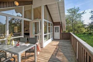 a porch of a house with a table and chairs at JB223-Brovst-Kronvildtvej-18 in Tranum