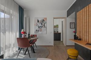 a living room with a dining room table and chairs at Garsoniera Turquoise Rezidential Moghioros Park in Bucharest