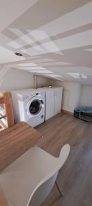 a room with a washing machine and a table at Maison de bourg in Jumeaux