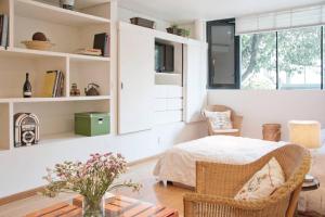 Schlafzimmer mit einem Bett, einem Tisch und einem Fenster in der Unterkunft L'Olive in Mexiko-Stadt