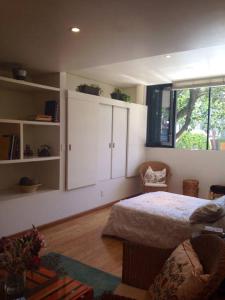 Schlafzimmer mit einem Bett, weißen Schränken und einem Fenster in der Unterkunft L'Olive in Mexiko-Stadt