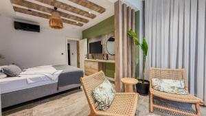 a bedroom with a bed and two chairs and a table at Leos Apartments Apart1 in Side