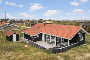 a house with an orange roof on top of a field at JB705-Frostrup-Svenstibakkevej-82 in Lild Strand