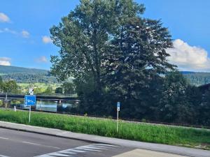 una carretera con un árbol al lado de una carretera en Le moulinot, en Morteau